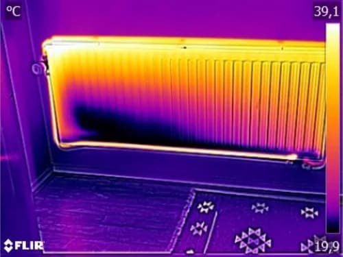 Foto van een radiator in een woonkamer van Jaga